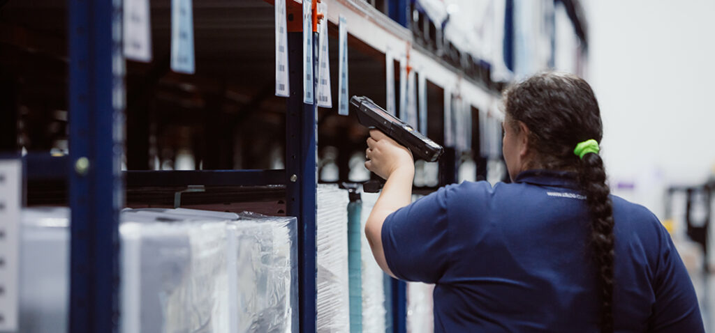 Female Worker Scanning Labels and Performing Quality Check in MMI Warehouse