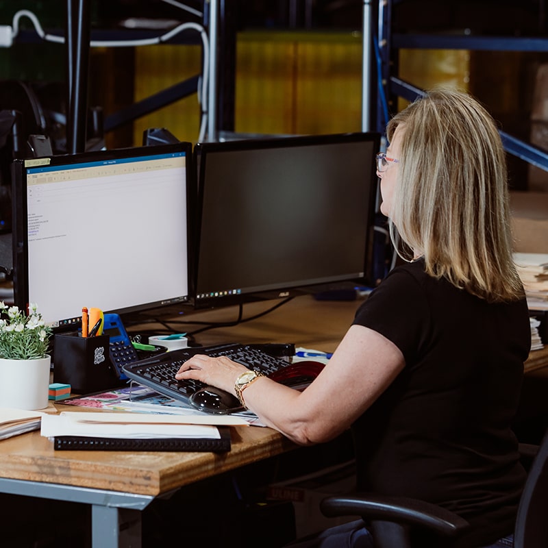 Employee Sitting in Front of Computer Providing Seamless Customer Services