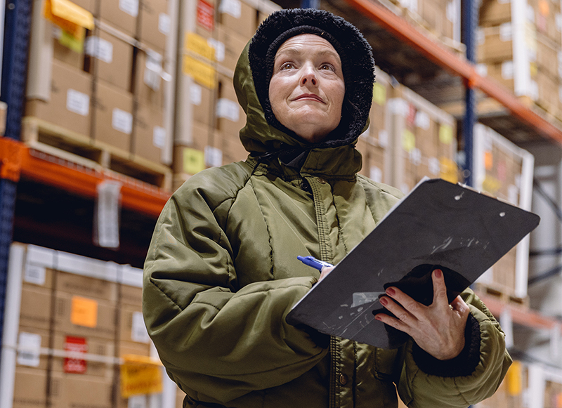 custom work solutions Female Worker in Hooded Jacket Inside Cold Storage Facility with Clipboard on Hand