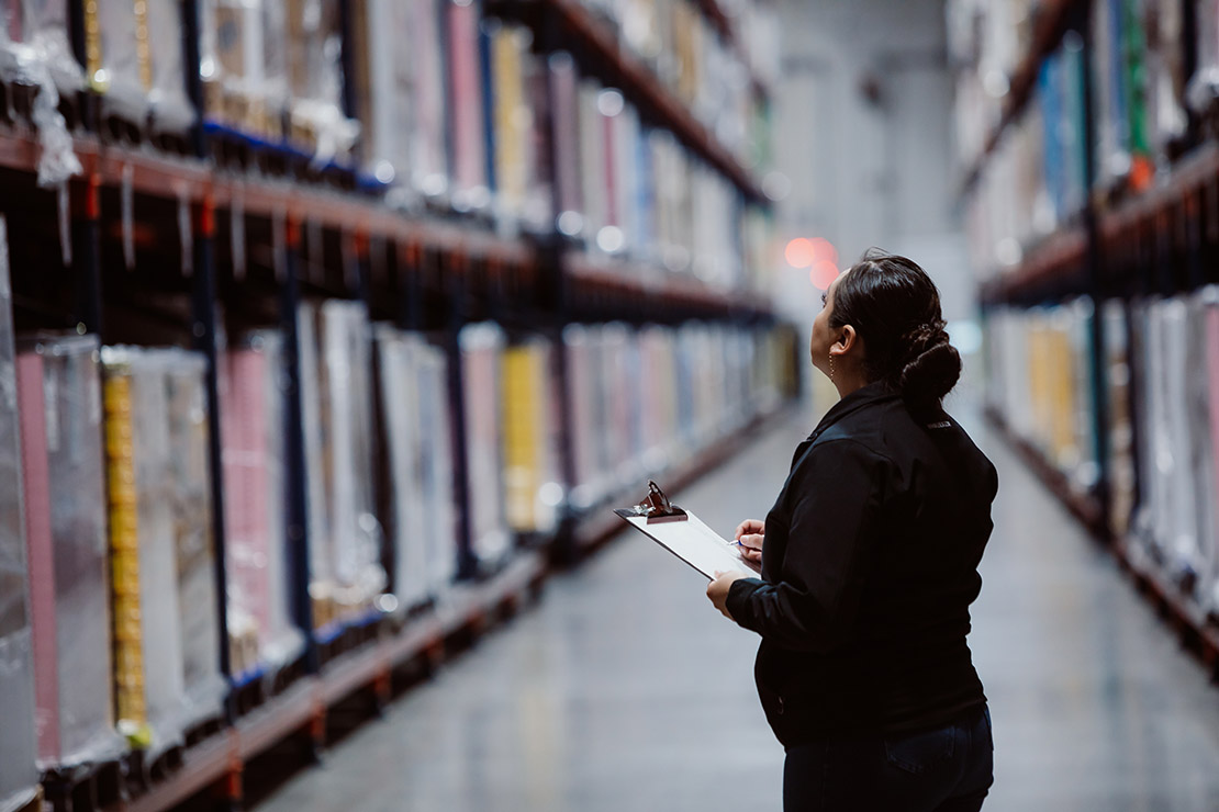 Female Worker Inside Large MMI Warehouse Performing Inventory