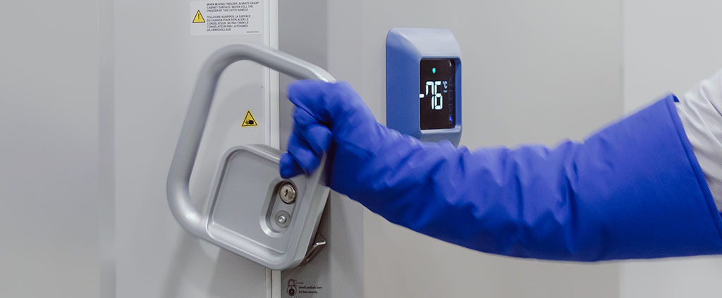 Worker Opening Door to Temperature Monitored Cold Chain Storage Facility