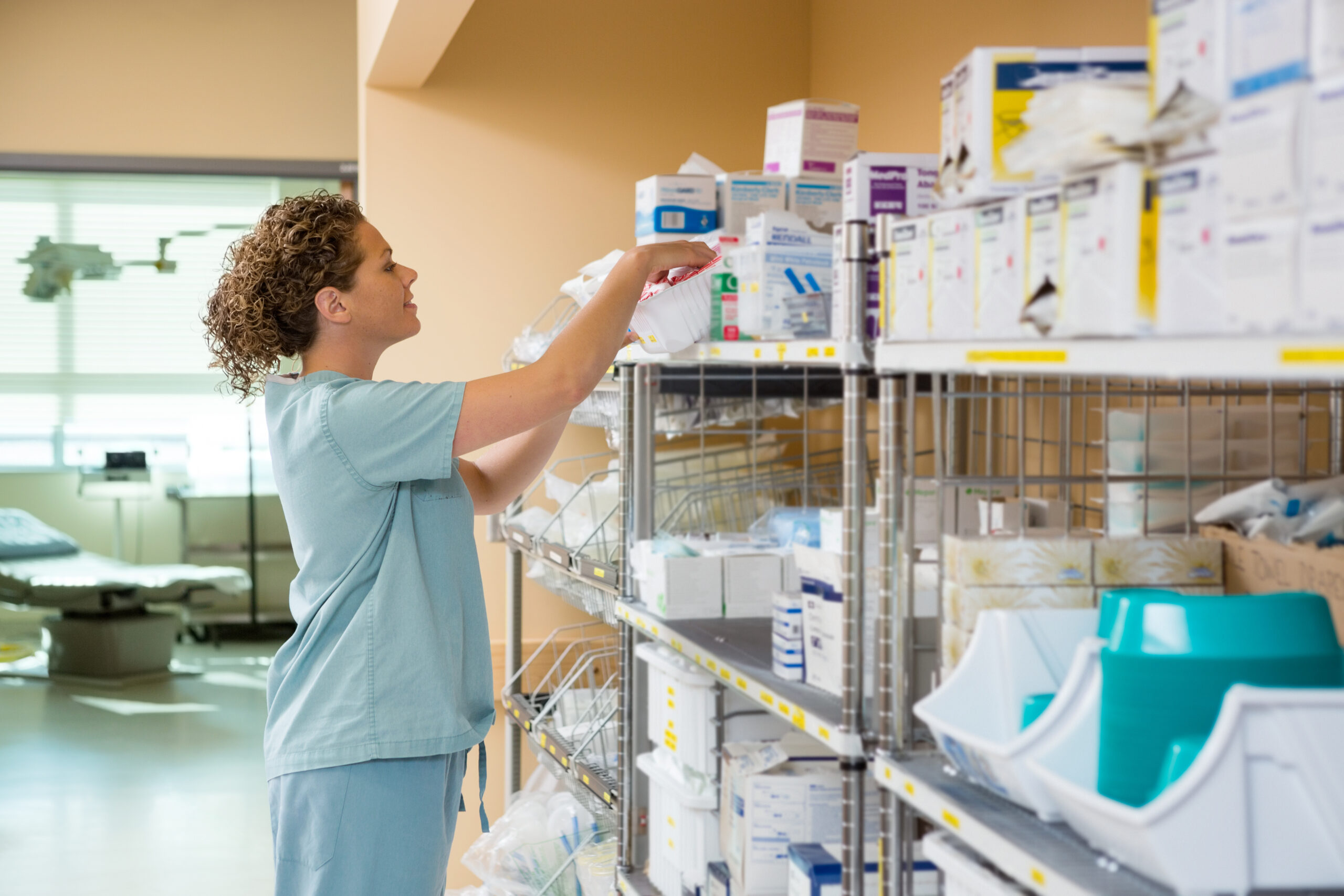 nurse working Side view of female nurse working in storage room of cancer hospital